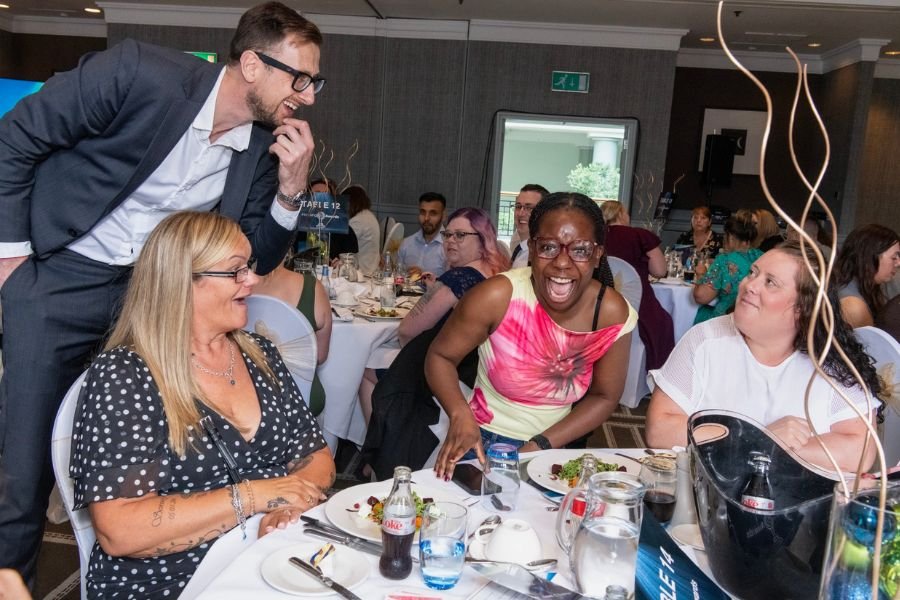 A table magician entertaining guests during a corporate dinner