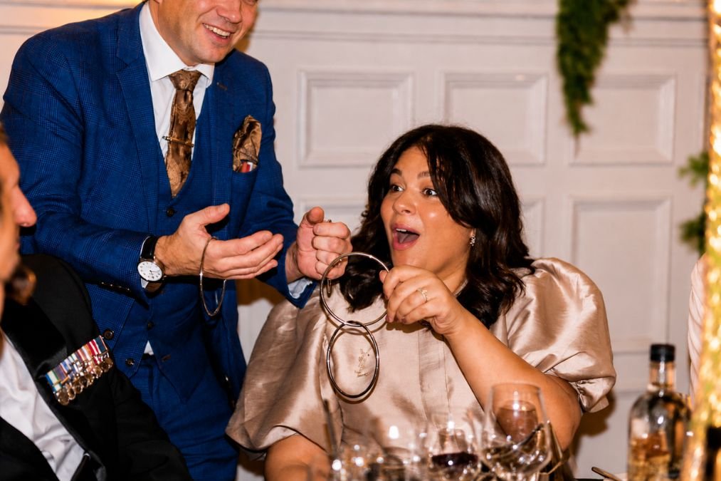 A guest astonished by a table magician at a gala dinner