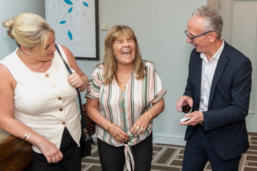 Guests reacting to a close-up magician at a corporate reception