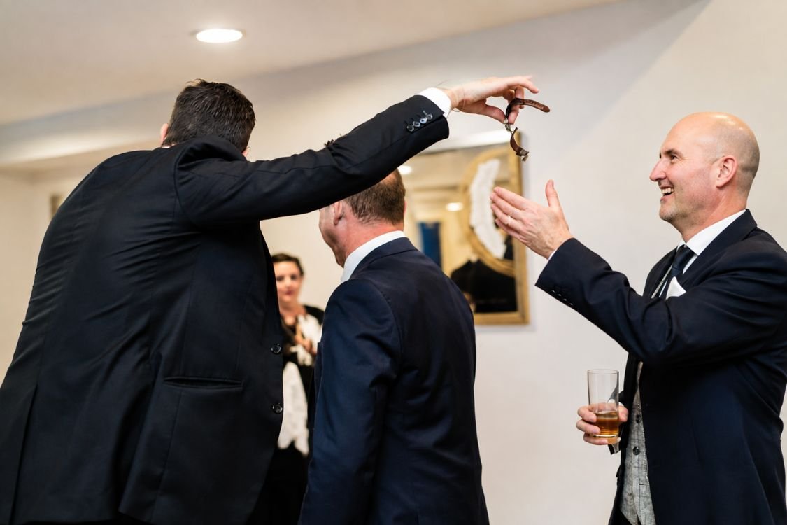 A pickpocket magician revealing a guest's lifted watch at a corporate event