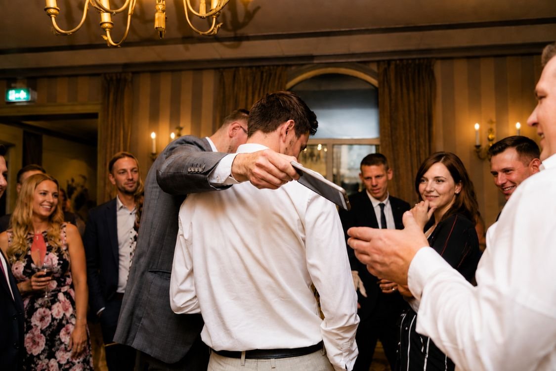 Corporate guests laughing at a pickpocket magician's reveal