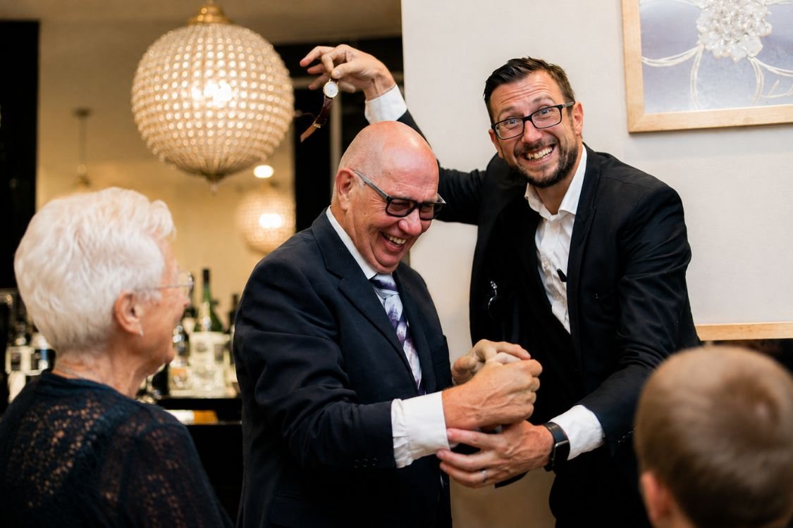 A guest realising a pickpocket magician has lifted their watch at a corporate event
