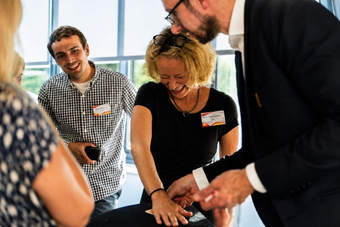 A corporate team learning close-up magic at a team building session