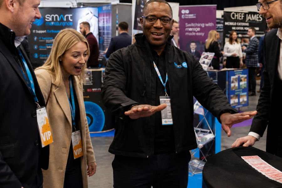 Trade show visitors reacting to close-up magic at a stand