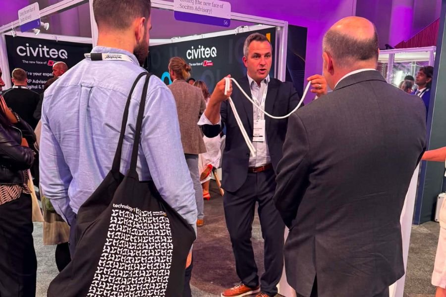 A trade show magician holding a crowd on a busy stand