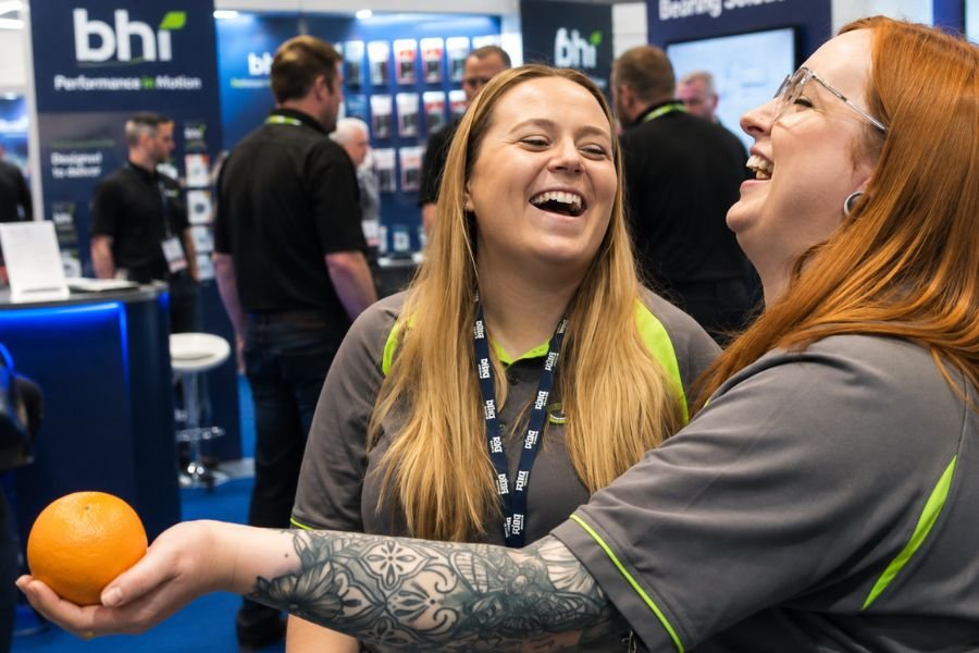 Visitors astonished by a close-up magician on an exhibition stand