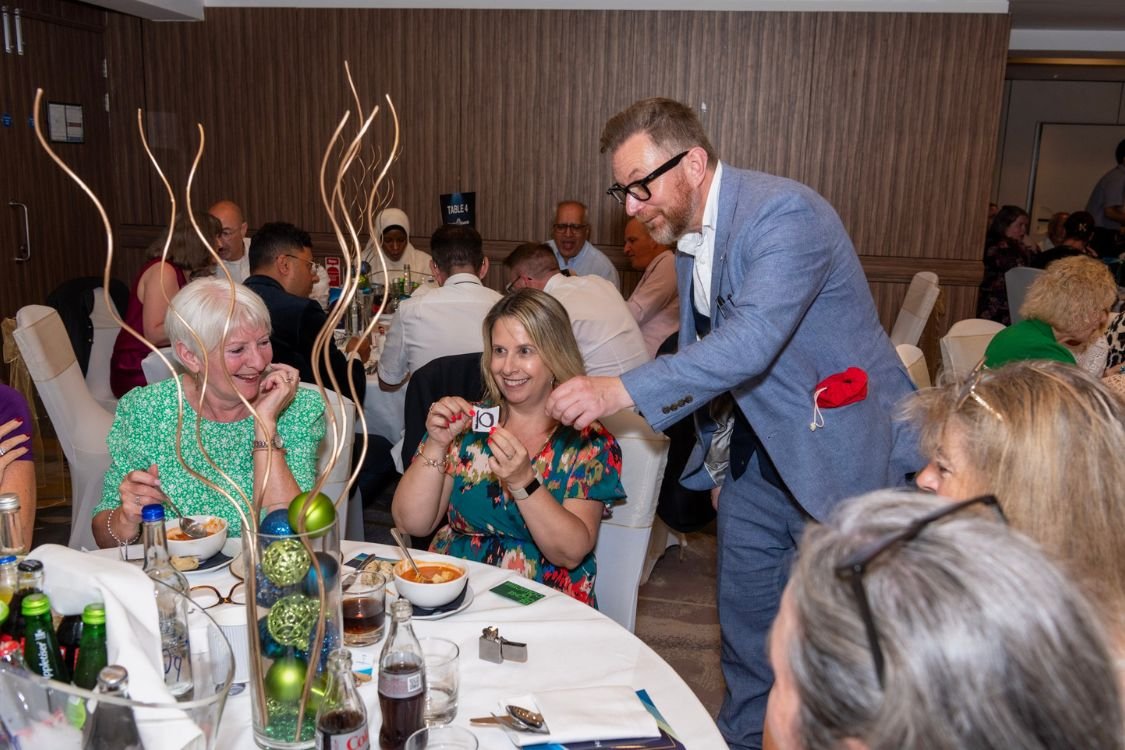 Corporate diners reacting to close-up magic at their table