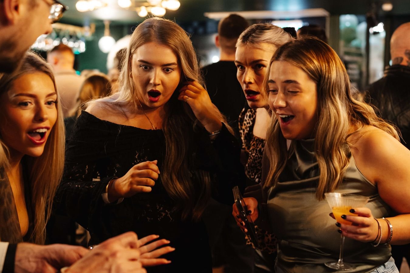 A corporate event photographer capturing a guest's reaction to close-up magic