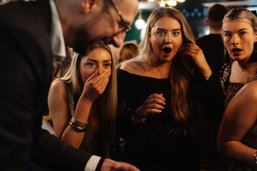 A table of guests laughing during magic